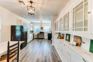 eine Küche mit weißen Schränken und einem schwarzen Kühlschrank in der Unterkunft Waco Vacation Rental Near Magnolia Market in Waco