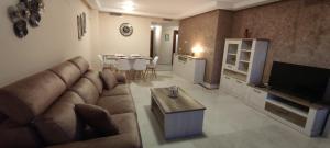 uma sala de estar com um sofá, uma televisão e uma mesa em Appart cosy Golf Garden Casares em Casares