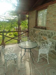 een patio met een tafel en stoelen op een veranda bij Cabañas Don Fernando in Santa Rosa de Calamuchita