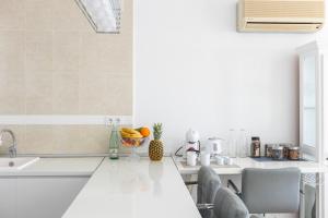Biała kuchnia ze zlewem i blatem w obiekcie Spacious Apartment in El Poble Nou de Benitatxell, Sea View w mieście Cumbre del Sol