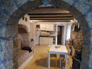 una cucina e un soggiorno con tavolo in un muro di pietra di Molise isernia è casa Sbriglio, tra cascate, laghi, fiumi e relax a Sessano Del Molise