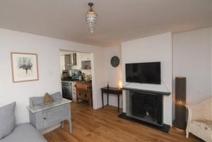 uma sala de estar com uma televisão de ecrã plano e uma lareira em Welcoming 2 bed townhouse near town centre & beach em Kent