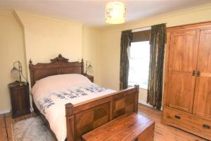 a bedroom with a wooden bed and a window at Welcoming 2 bed townhouse near town centre & beach in Kent