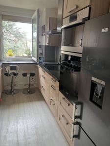 a kitchen with stainless steel appliances and a window at Chambre d hote au calme in Brétigny-sur-Orge