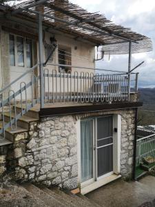 una casa in pietra con balcone e finestra di Molise isernia è casa Sbriglio, tra cascate, laghi, fiumi e relax a Sessano Del Molise