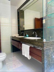 ナタールにあるVilla Brunnaの洗面台、鏡、トイレ付きのバスルーム