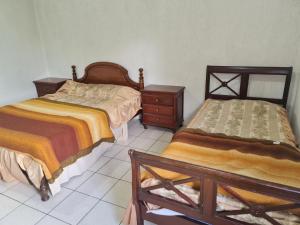 una camera con 2 letti, un comò e sidx sidx sidx di Residencial Mogi das Cruzes a Mogi das Cruzes