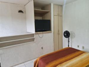 a room with a bed and a tv on the wall at Residencial Mogi das Cruzes in Mogi das Cruzes