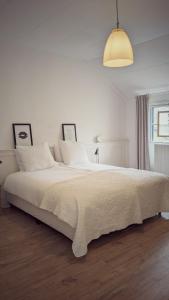a white bedroom with a large bed with white sheets at Vita Nova in Hippolytushoef