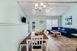 a living room with a table and a blue couch at Shark's Key in Port Aransas