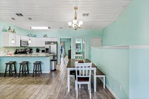- une cuisine avec des murs bleus, une table et des chaises dans l'établissement Shark's Key, à Port Aransas