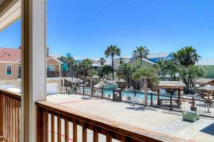 a balcony with a view of a pool and palm trees at Shark's Key in Port Aransas