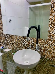 La salle de bains est pourvue d'un lavabo blanc et d'un miroir. dans l'établissement Hotel dos PRAZERES (Motel), à Récife