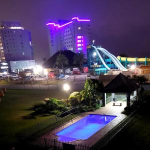 a swimming pool at night in a city with buildings at Diaz De Valle 35 in Mossel Bay