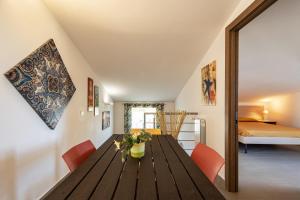 a dining room with a wooden table and orange chairs at Borgo Aranci - Appartamento in Villa Rosa - 16B in Castellammare del Golfo