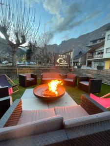 a fire pit in the middle of a yard with chairs at Hotel Els Encantats in Espot