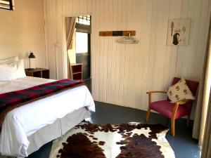 1 dormitorio con 1 cama, 1 silla y 1 alfombra en 180 at Mission House en Curryʼs Post