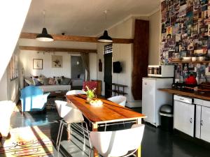 a kitchen and living room with a wooden table and chairs at 180 at Mission House in Curryʼs Post