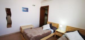een kleine slaapkamer met een bed en een bank bij Casina Raho B&B in Nardò