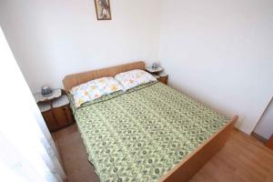 ein Schlafzimmer mit einem Bett mit einer grünen Bettdecke in der Unterkunft Apartments in Jadranovo 39275 in Jadranovo
