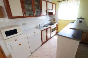 eine Küche mit weißen Geräten und einem Waschbecken in der Unterkunft Apartments in Jadranovo 39275 in Jadranovo