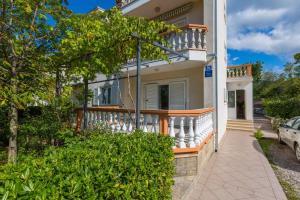 ein Haus mit einem Balkon und einer Auffahrt in der Unterkunft Apartments in Jadranovo 39275 in Jadranovo