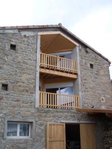 a stone building with a balcony on the side of it at Gîte Le Croquant in Colombier