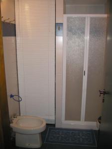 een kleine badkamer met toilet en douche bij Appartamento con piscina e aria condizionata in La Maddalena +27 foto's