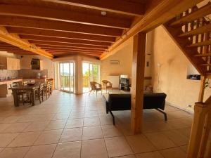 a large living room with a table and a kitchen at Gîte Le Croquant in Colombier