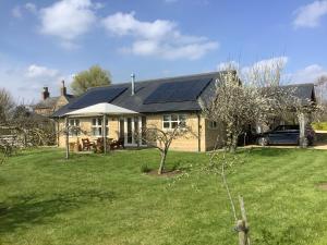 a house with solar panels on the roof at Orchard Cottage, Clematis cottages, Stamford. Accessible luxury home. in Stamford