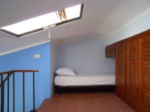 een kleine kamer met een bed en een dakraam bij Appartamento con piscina e aria condizionata in La Maddalena