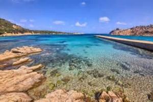 een grote hoeveelheid water met rotsen en riffen bij Appartamento con piscina e aria condizionata in La Maddalena