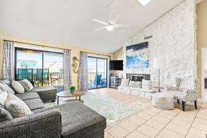 a living room with couches and a stone wall at No Hurry - 302 in Myrtle Beach
