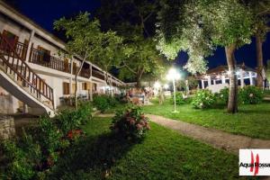 un edificio con una luz de la calle en un patio por la noche en Hotel Kokkino Nero en Kókkinon Nerón