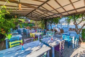 a restaurant with blue tables and chairs and the water at Giritimu Evleri in Selimiye