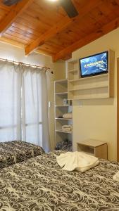 a bedroom with a bed and a tv on the wall at Aranjuez Real in Villa Carlos Paz