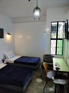 Cette chambre comprend deux lits, une table et des chaises. dans l'établissement Balai ni Meno, à Butuan