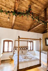 - une chambre avec un lit et un plafond en bois dans l'établissement Èlia Luxury Rooms, à Areópoli