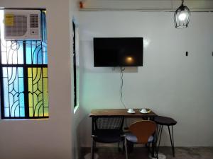 a room with a table and chairs and a tv on a wall at Balai ni Meno in Butuan