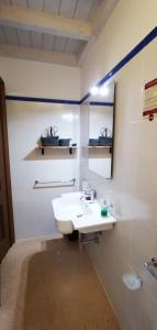 Baño blanco con lavabo y espejo en Casina Raho B&B, en Nardò
