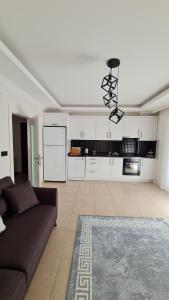 een woonkamer met een bank en een keuken bij Nimet Aydın Apartmanı in Alanya
