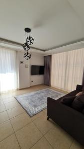 een woonkamer met een bank en een flatscreen-tv bij Nimet Aydın Apartmanı in Alanya