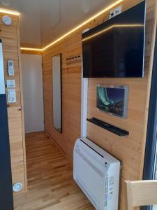 a small room with a tv and a television console at Hausboot am See in Rieth