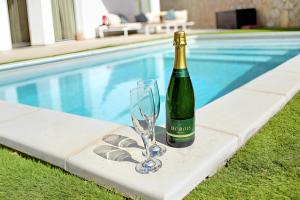 una botella de vino y una copa junto a la piscina en Escape to paradise luxury Poolvilla with ocieanview near Amadores, en Mogán
