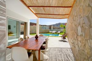 a dining room with a wooden table and chairs at Escape to paradise luxury Poolvilla with ocieanview near Amadores in Mogán