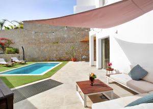 a patio with a swimming pool and a villa at Escape to paradise luxury Poolvilla with ocieanview near Amadores in Mogán