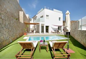 Villa mit einem Pool, 2 Stühlen und einem Sonnenschirm in der Unterkunft Escape to paradise luxury Poolvilla with ocieanview near Amadores in Mogán