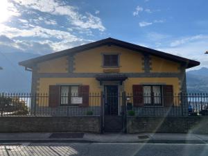 a yellow house with a fence in front of it at Villa Angela in Dorio