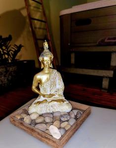 a gold statue sitting on a tray of rocks at Au Doux Refuge in Le Lambert