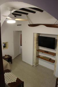 Evanthea Residence في كونوبيدهيانا: غرفة معيشة مع تلفزيون بشاشة مسطحة على جدار